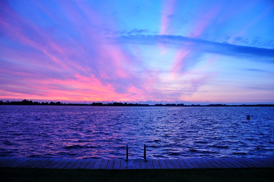 Lumière photo heure bleue sur la mer avec un ciel zébré de rose et de marine