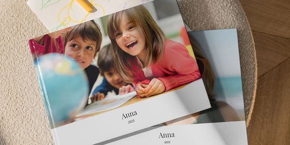 Deux livres photo superposés. La photo du haut est celle d'un enfant souriant en uniforme scolaire.